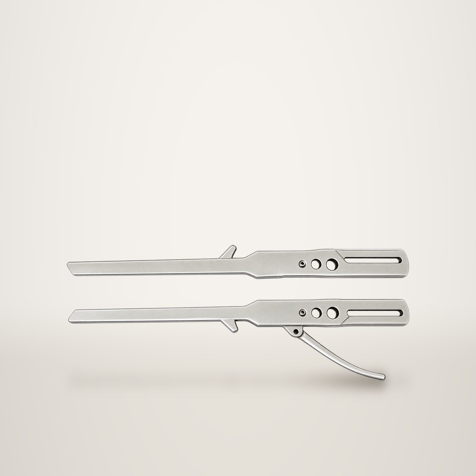 Deux pièces métalliques longues et étroites, percées de plusieurs trous, posées côte à côte sur un fond uni clair.