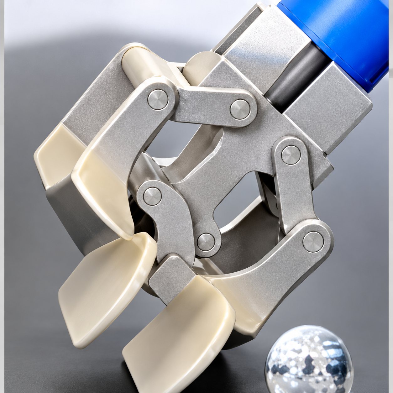 Gros plan sur un outil de préhension mécanique aux mâchoires articulées blanches et grises, fixé à un manche bleu, sur fond clair.